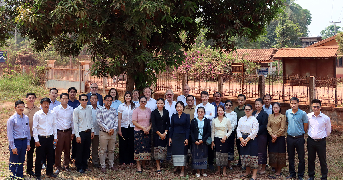 Group photo of meeting participants in front of a tree