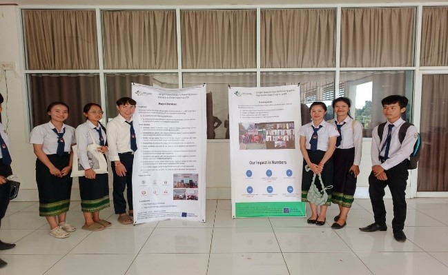 University students standing next to two posters