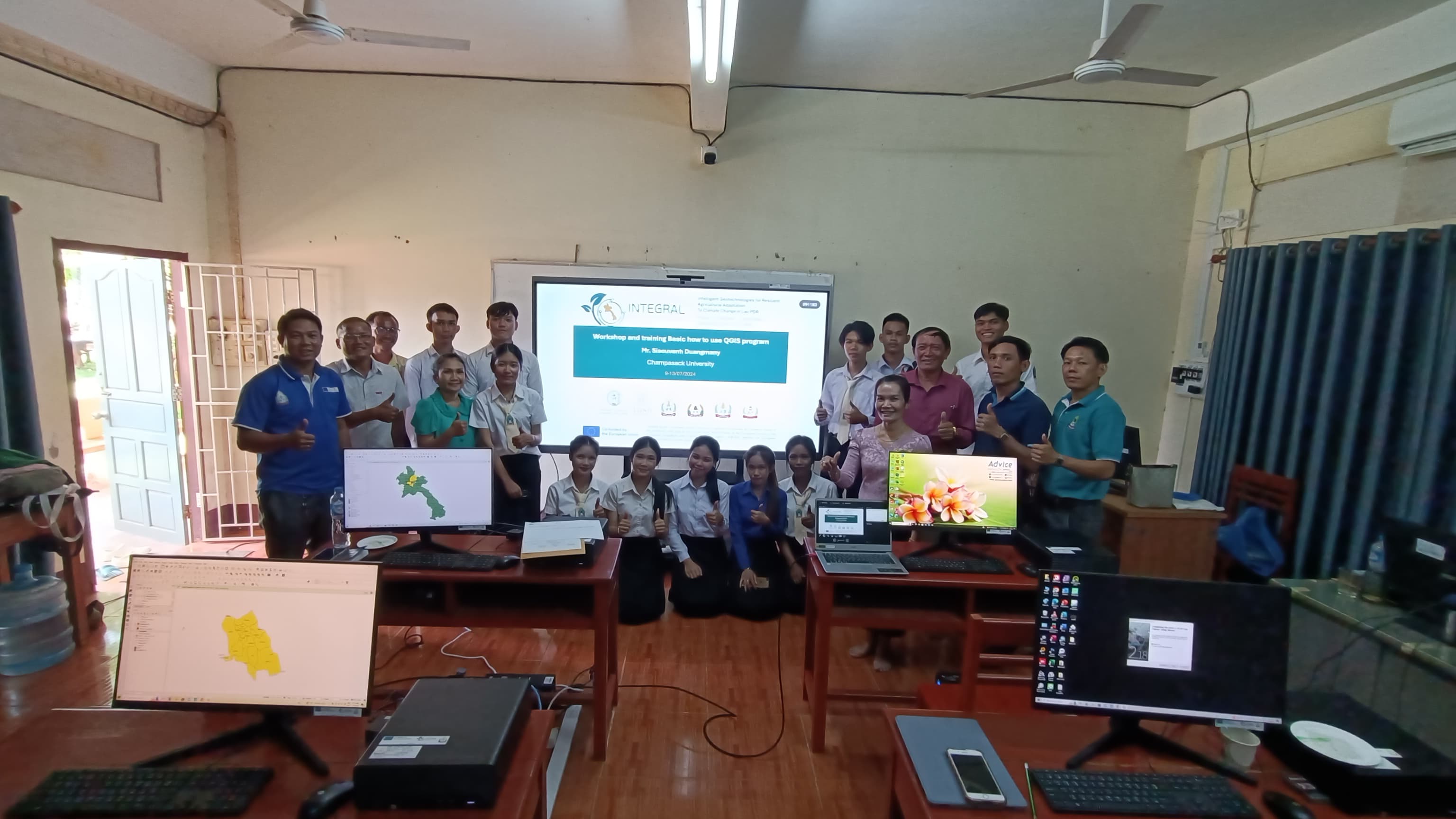 Group photo of university instructors and students pointing their thumbs up