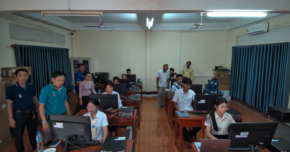 Students working in a computer lab with supervisors