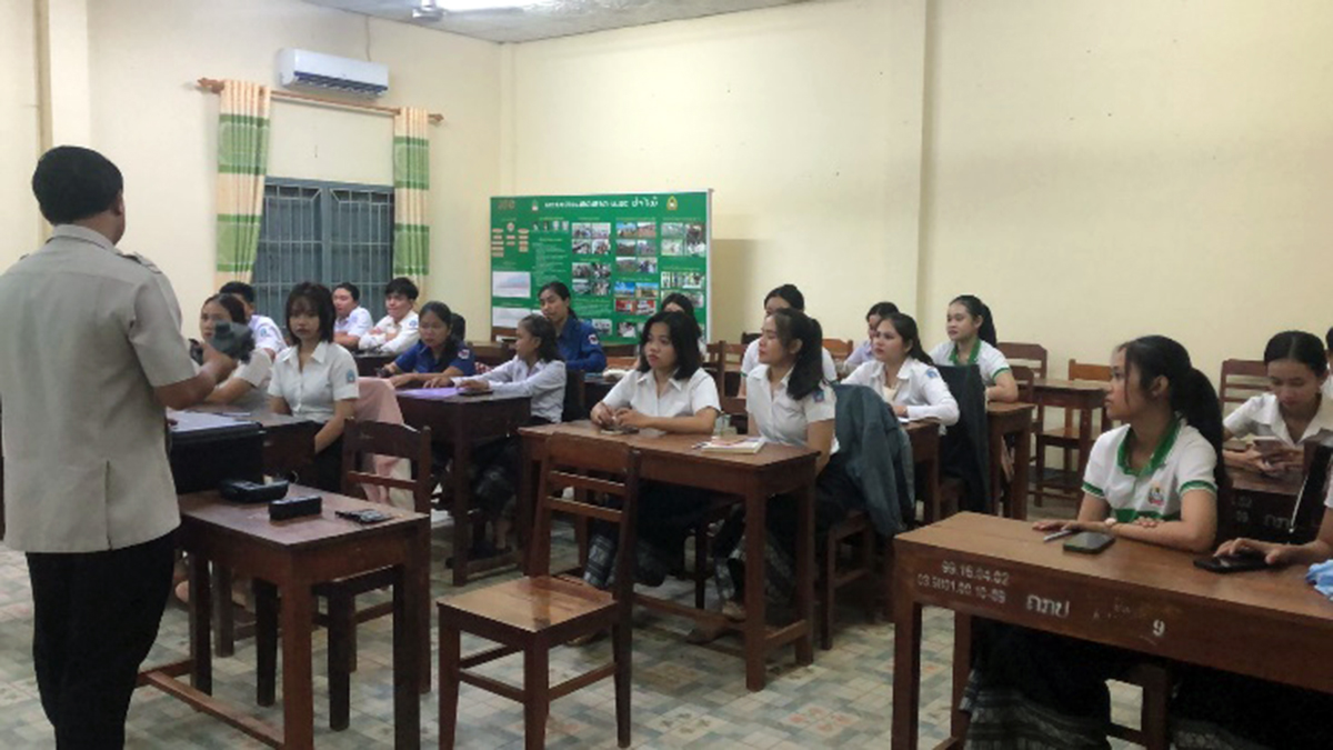 An instructor showing a drone to students in a classroom