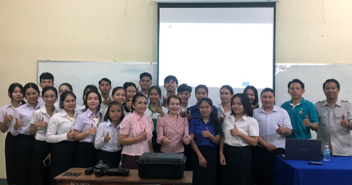 Group photo of university instructors and students with thumbs up