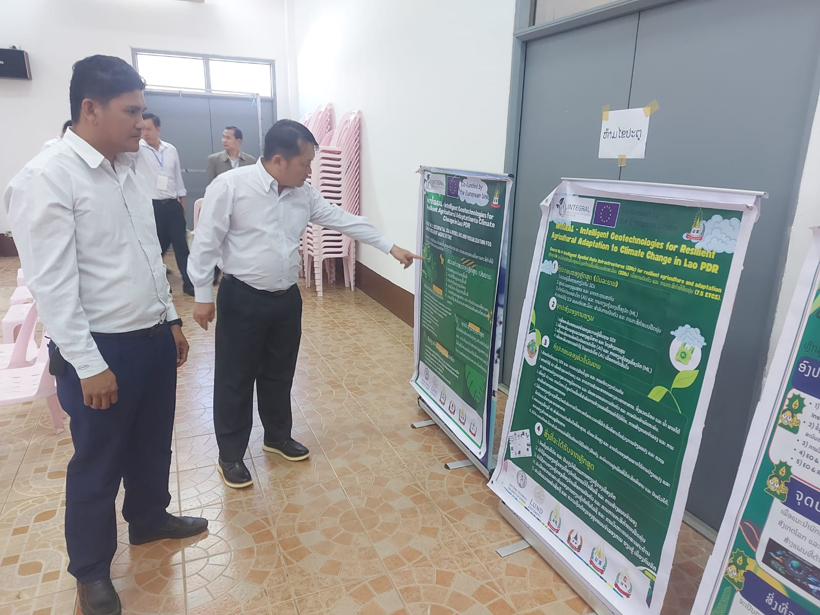 Two men examining a poster