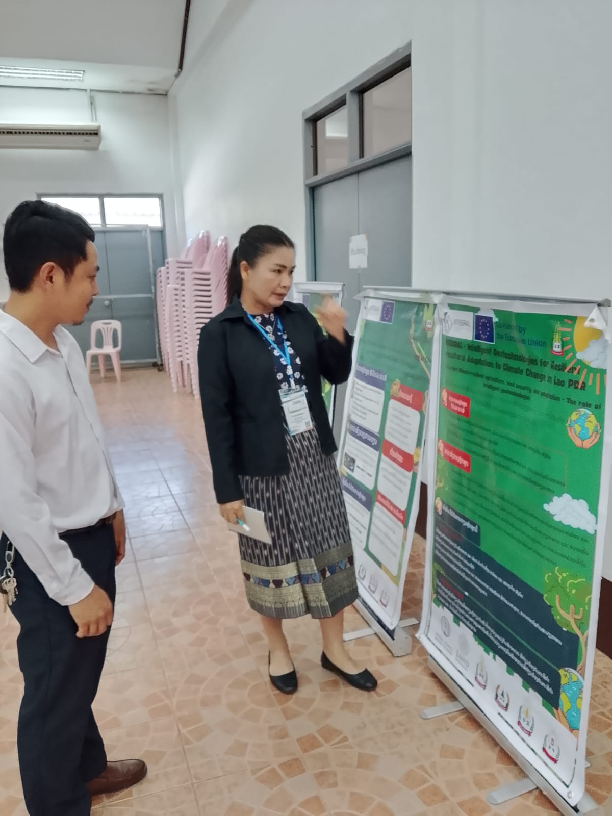 A woman showing a poster to a young man